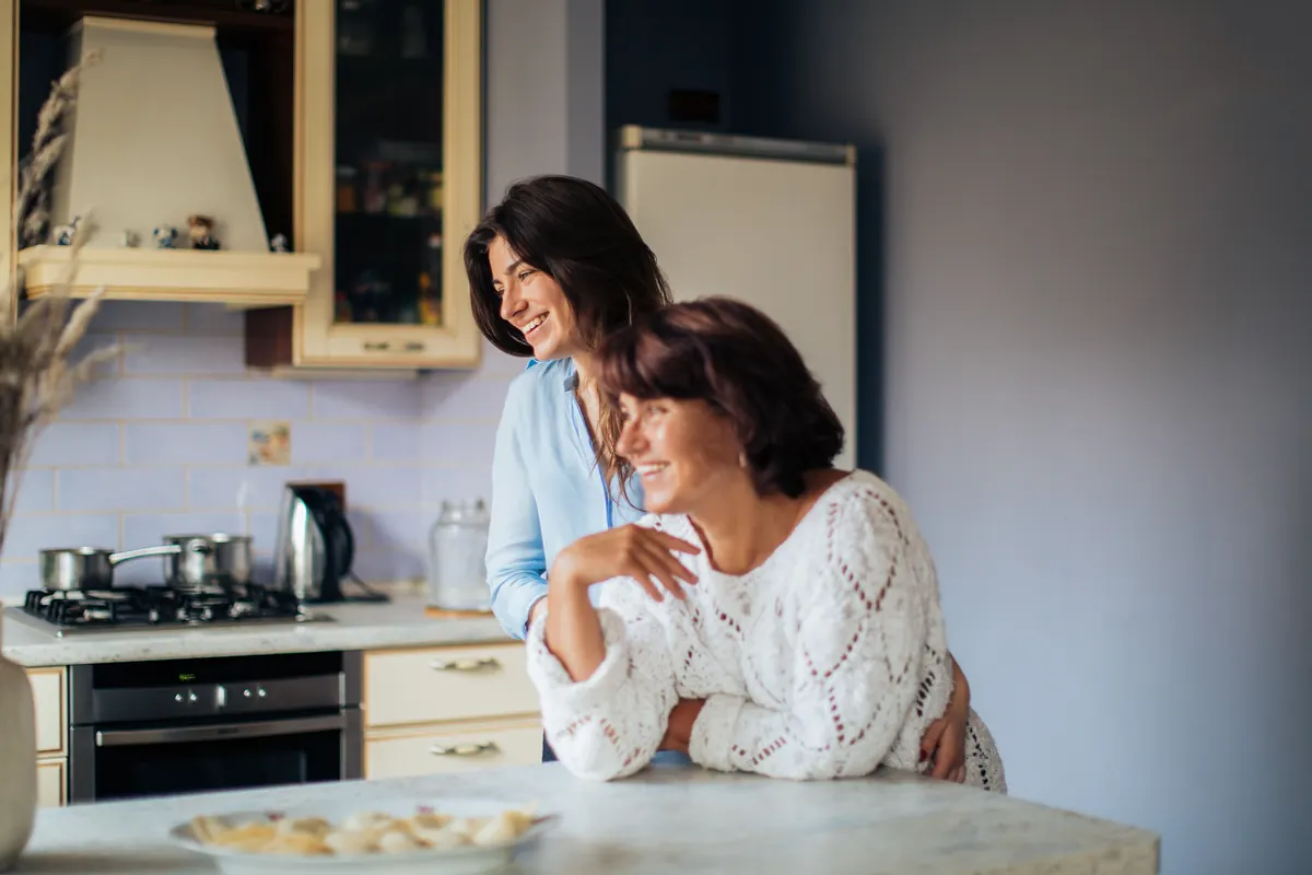 Adult daughter talking with her elderly mother at home