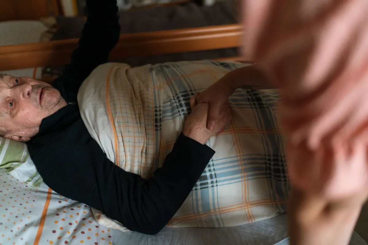 Caregiver gently holding the hands of a senior woman